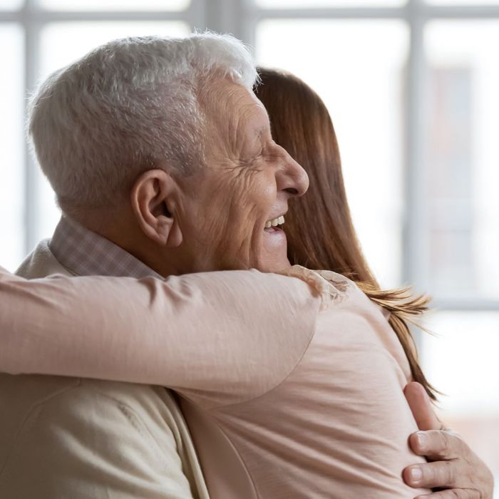 an adult daughter hugging her elderly father