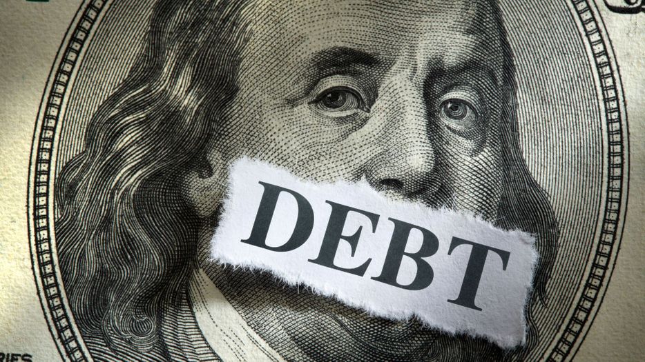 Closeup of a 100 dollar bill with debt written on it Closeup of a 100 dollar bill with debt written on it